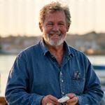 António, pescador artesanal, sorrindo com a sua pesca