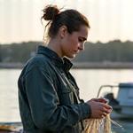 Sara, jovem pescadora, a inspecionar uma rede